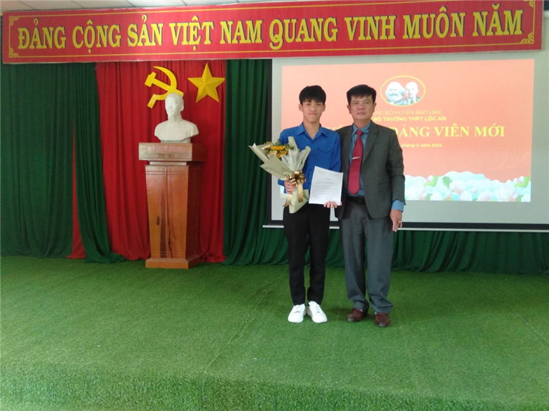 Đ/c Võ Nhật Trí, bí thư chi bộ, hiệu trưởng nhà trường trao quyết định cho đảng viên Lê Nguyễn Quốc Đạt 