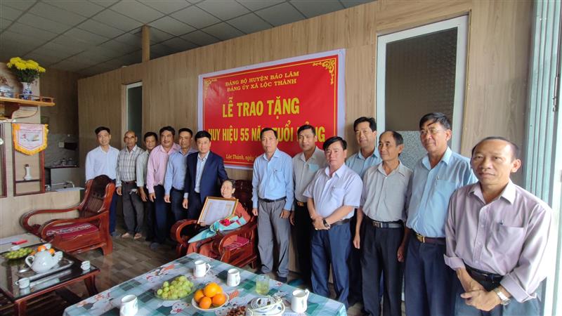 Các đồng chí lãnh đạo Huyện ủy, UBND huyện và địa phương chụp hình lưu niệm cùng đảng viên Võ Thị Hồng Toán