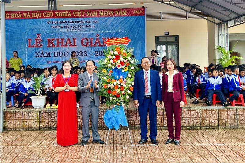 Đ/c K’Lình – Phó Bí thư Thường trực Huyện uỷ - Chủ tịch HĐND huyện tặng hoa chúc mừng nhà trường