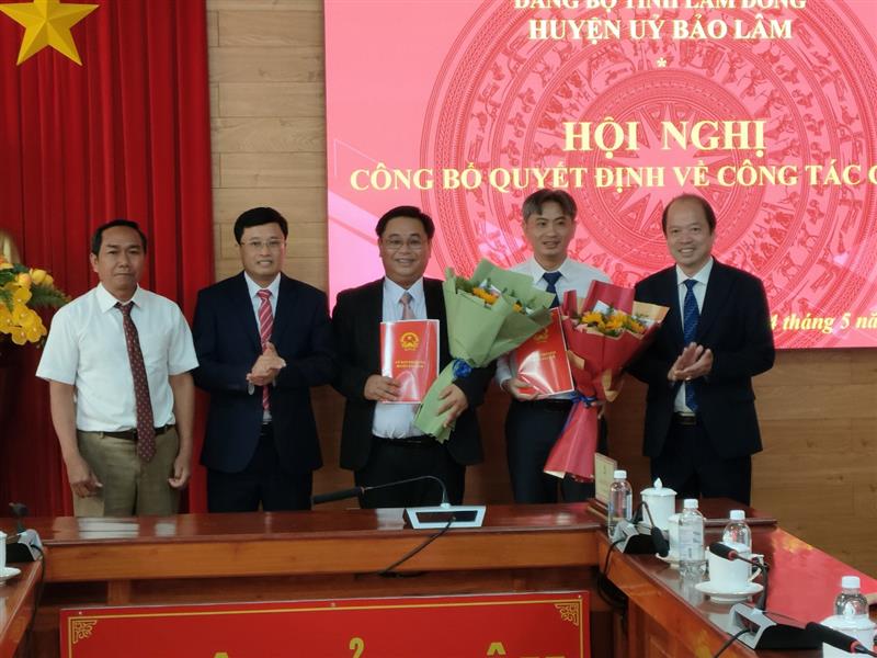 Các đồng chí Thường trực Huyện ủy trao quyết định và tặng hoa cho đồng chí Chánh Thanh tra huyện và Phó trưởng phòng VHTT huyện